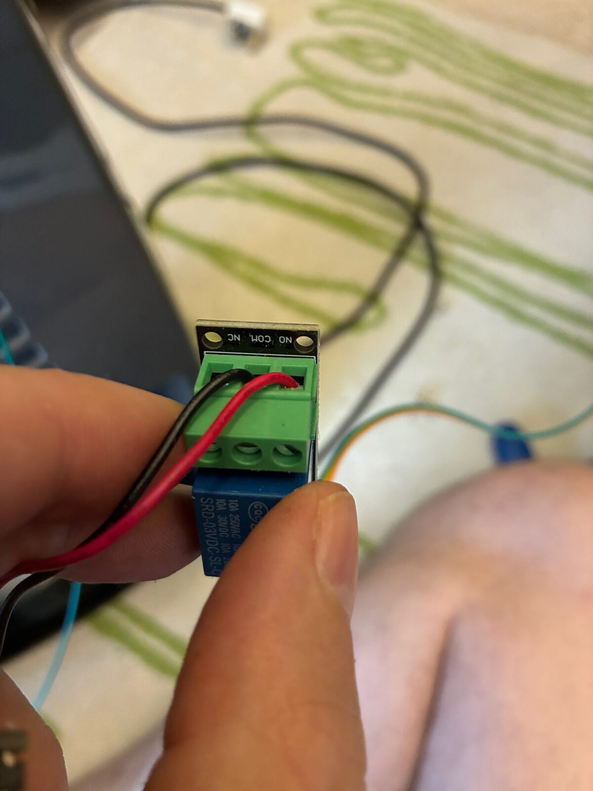 The original relay module wired across the ON/OFF button